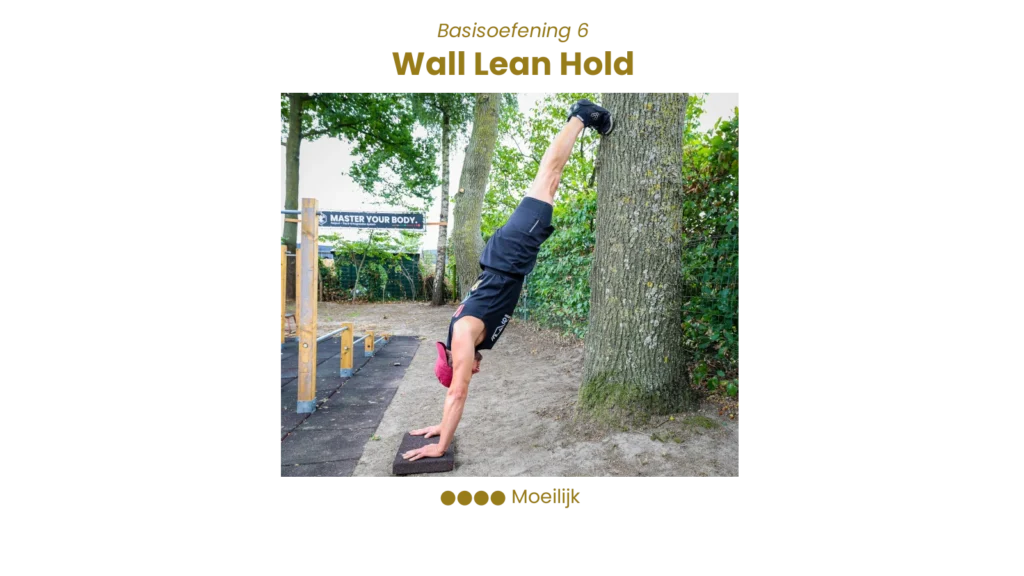 Fenjo in wall lean hold: gestrekte handstandpositie met voeten tegen de muur, core aangespannen – niveau moeilijk.